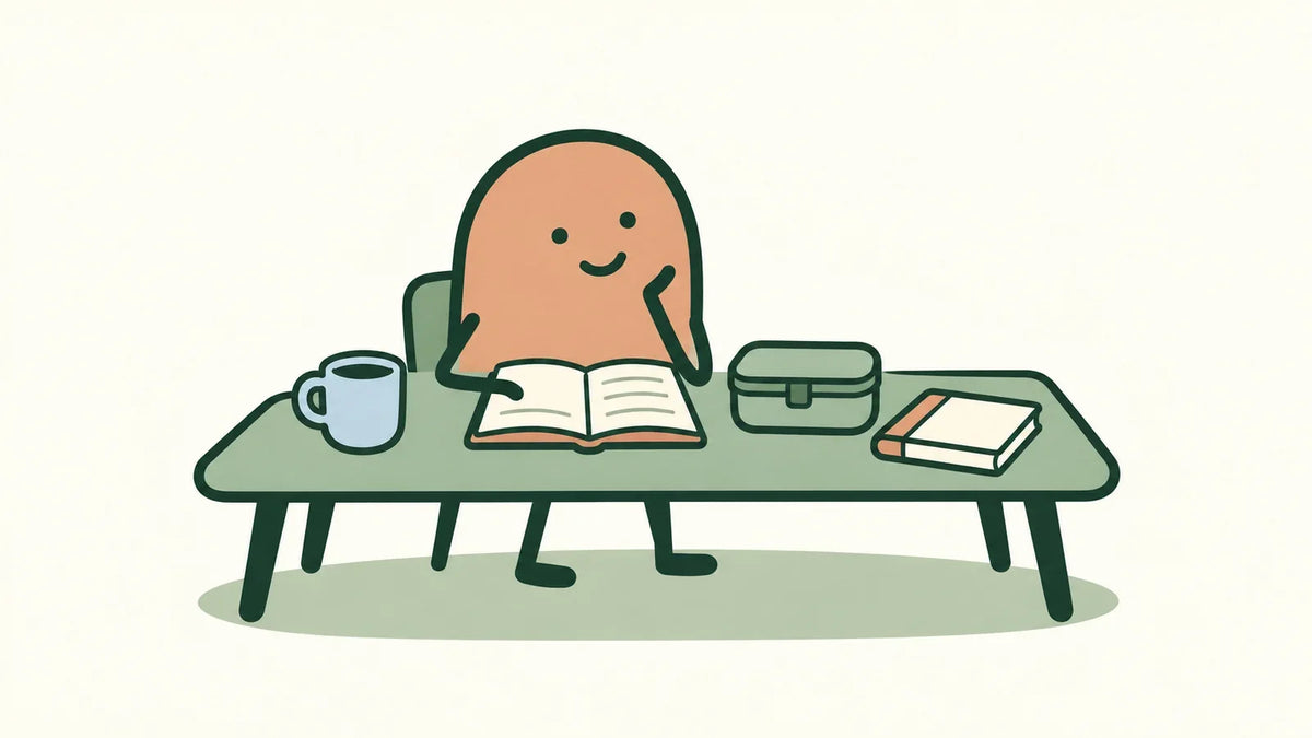 A terracotta character reviews a notebook beside a cup, lunch container, and small book.
